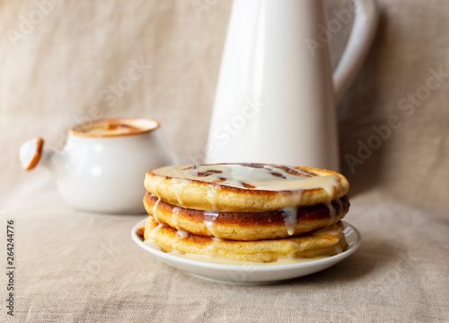 Delicious homemade pancakes with caramel sauce and milk. Close-up. Light background