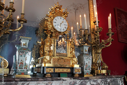clock, vases and candlesticks on a mantlepiece in a castle in france 