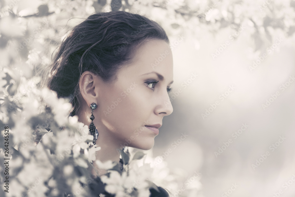 Beautiful fashion woman walking in a spring blooming garden Beautiful fashion woman walking in a spring blooming garden