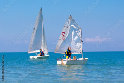 Child sailing. Kid learning to sail on sea yacht. photo
