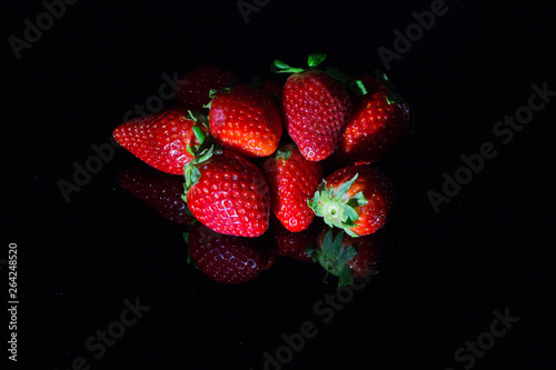 Fresh strawberries isolated on black background with reflections