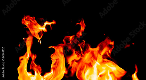 Fire flames on Abstract art black background, Burning red hot sparks rise, Fiery orange glowing flying particles © Thicha