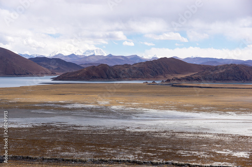 Tibetan landscape near holy lake Yamdrok with snowy mountains in the background- Tibet