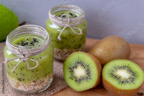 Kiwi smoothie with cereal on a wooden table.