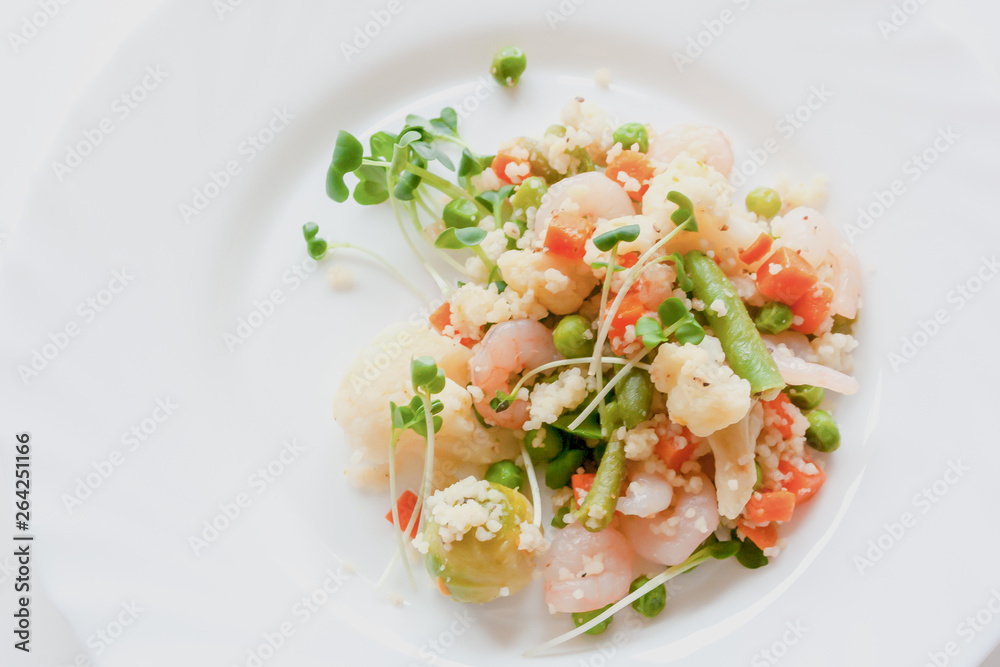 couscous with vegetables, shrimp and radish on a white plate couscous with vegetables, shrimp and radish on a white plate