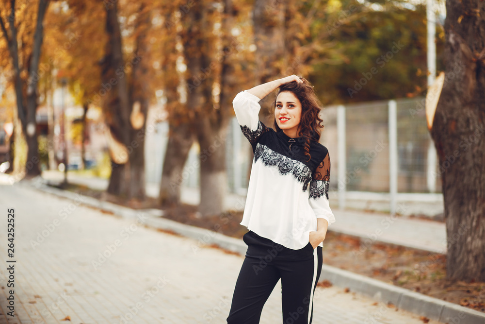Fototapeta premium The girl is outdoors. Woman in autumn street. Beautiful girl smile