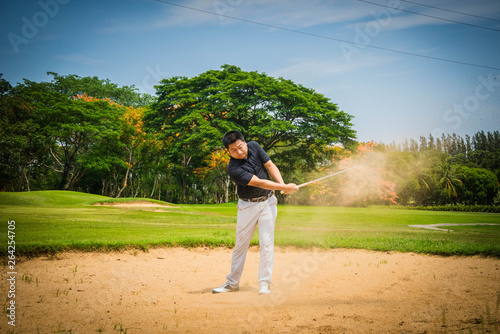 Golfer putting golf into the hole in beautiful golf course. The evening golf course with sunset in thailand