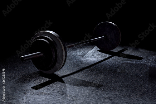 Olympic weights in gym with dramatic lighting