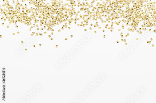 Golden sequins texture on white isolated background. Flat lay with copy space