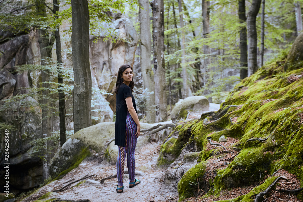 Young attractive girl stand between trees in forest Young attractive girl stand between trees in forest