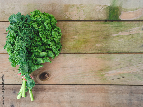Bunch of kale on wooden background.
