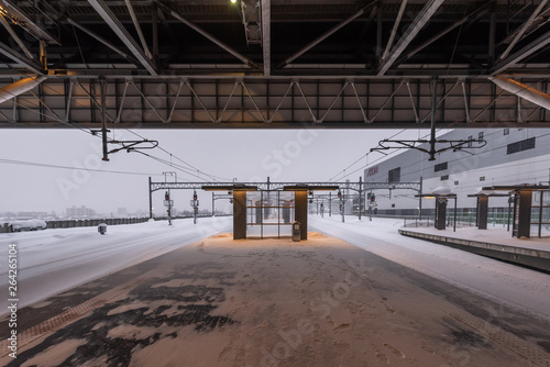 Empty railway and platform covered with white snow