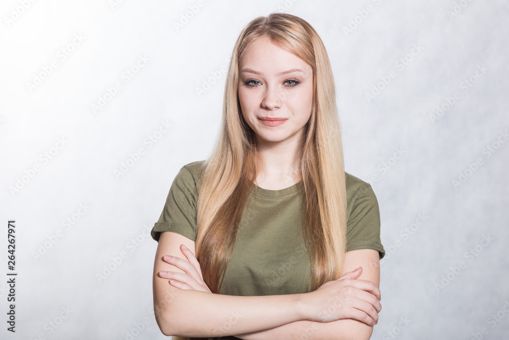 Fototapeta premium Portrait of a young beautiful smiling woman on a gray background.