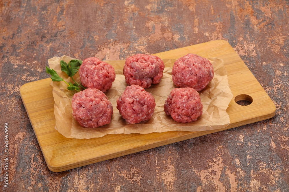 Raw meatball over wooden background Raw meatball over wooden background