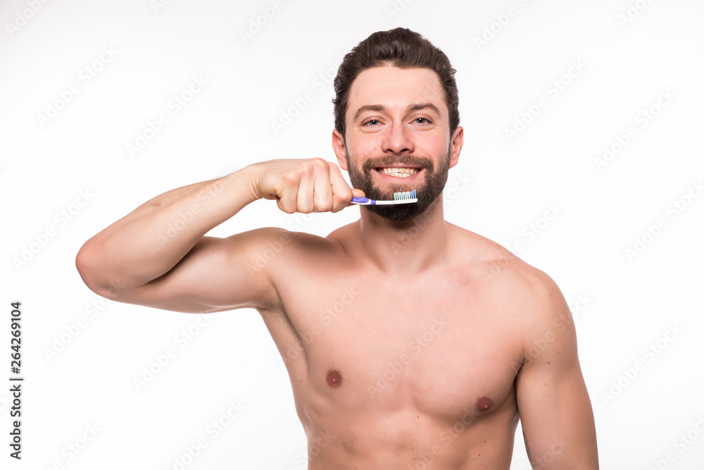 Fototapeta premium Handsome young man brushing his teeth isolated on white background