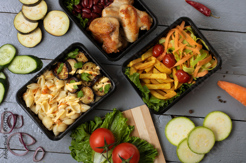 three plastic food containers with cherry tomatoes, fried pasta and cheese, eggplants and zucchini
