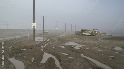 Cars driving on a misty coastal road at Barrow, Alaska