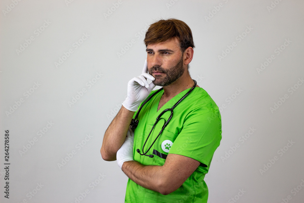 Portrait of male veterinary doctor in green uniform with brown hair worried, facing forwards and looking at the horizon. Isolated on white background. Portrait of male veterinary doctor in green uniform with brown hair worried, facing forwards and looking at the horizon. Isolated on white background.
