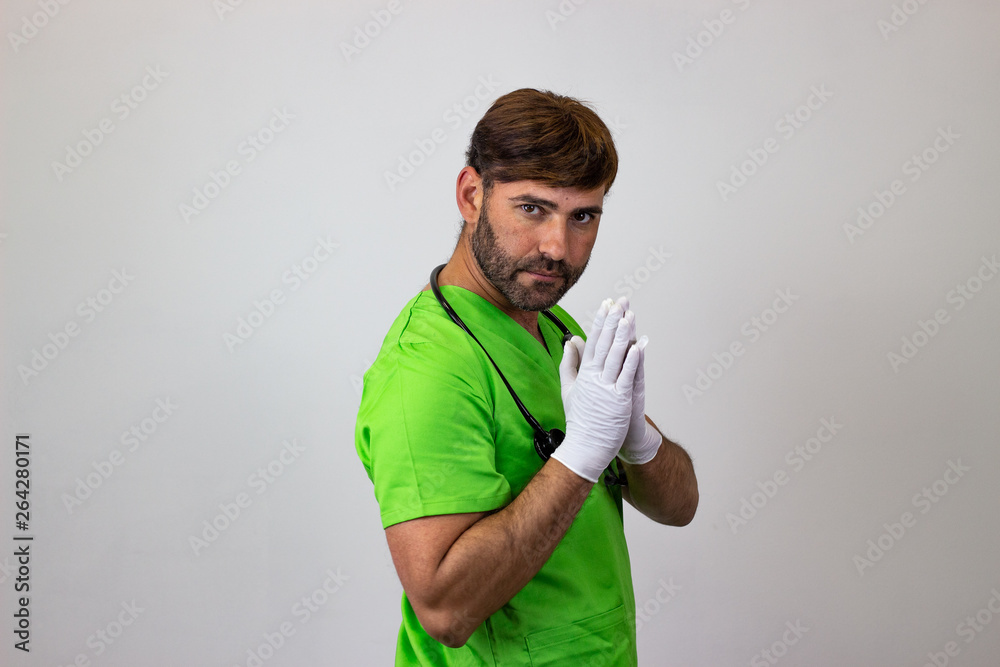 Portrait of male veterinary doctor in green uniform with brown hair regretful, their back facing the camera and looking at the camera. Isolated on white background.