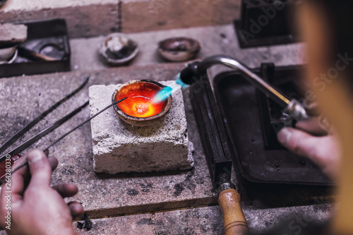 Melting precious metals in the crucible. Workflow in a jewelry workshop close-up photo