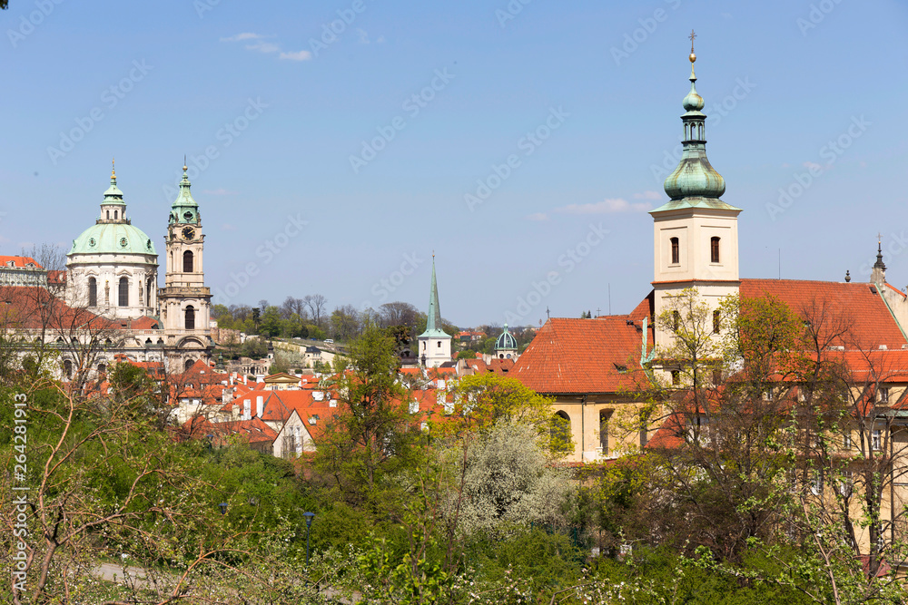 Spring Prague City with St. Nicholas' Cathedral and the green Nature and flowering Trees, Czech Republic