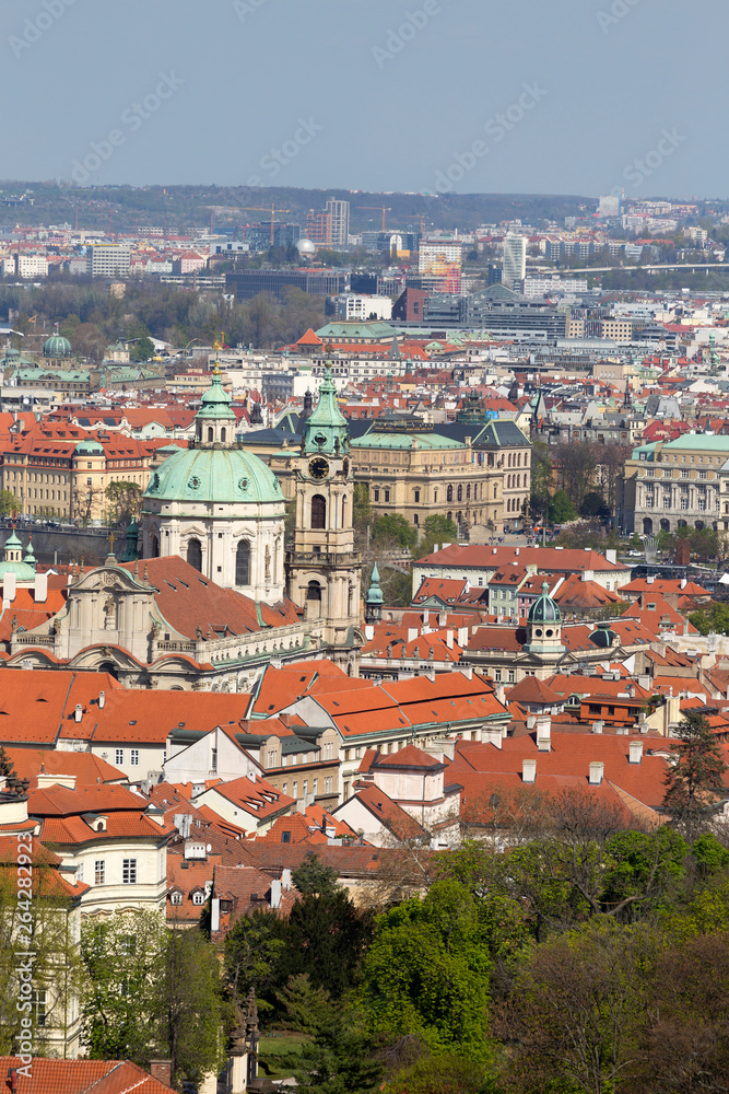 Obraz premium Spring Prague City with St. Nicholas' Cathedral and the green Nature and flowering Trees, Czech Republic