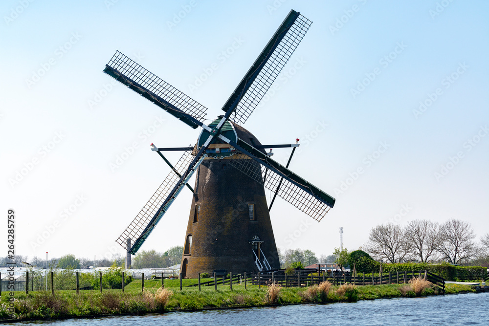 Traditional Dutch wind mill built along the canal in North Holland, spring landscape