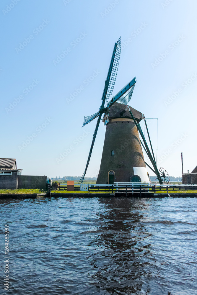 Waterways of North Holland and view on traditional Dutch wind mill, spring landscape Waterways of North Holland and view on traditional Dutch wind mill, spring landscape