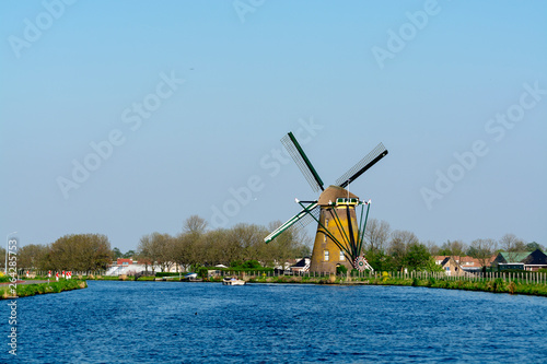 Waterways of North Holland and view on traditional Dutch wind mill, spring landscape