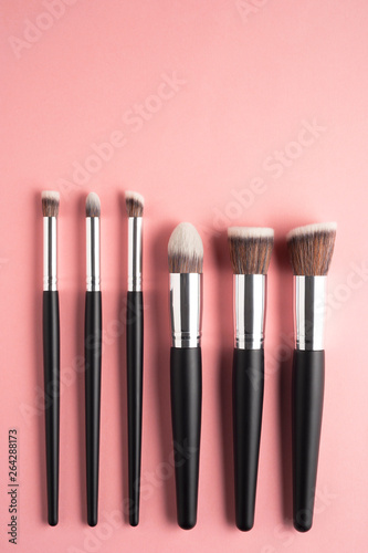 Creative concept beauty fashion photo of cosmetic product make up brushes kit on pink background.