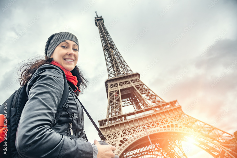 Fototapeta premium Young woman tourist against the background of the Eiffel Tower in Paris the capital of France.