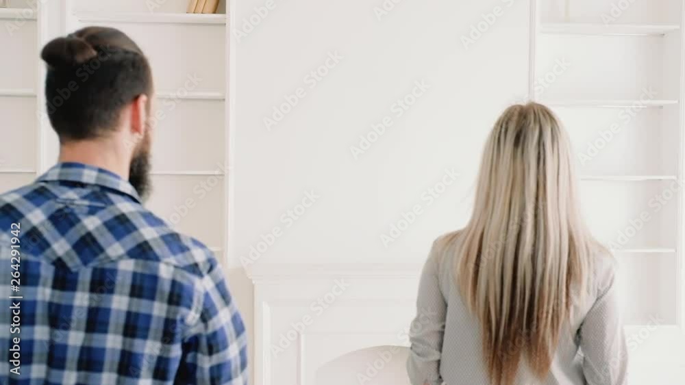 Real estate agent selling new modern house, telling clients about its advantages. Young couple enthusiastic about stylish place. Real estate agent selling new modern house, telling clients about its advantages. Young couple enthusiastic about stylish place.