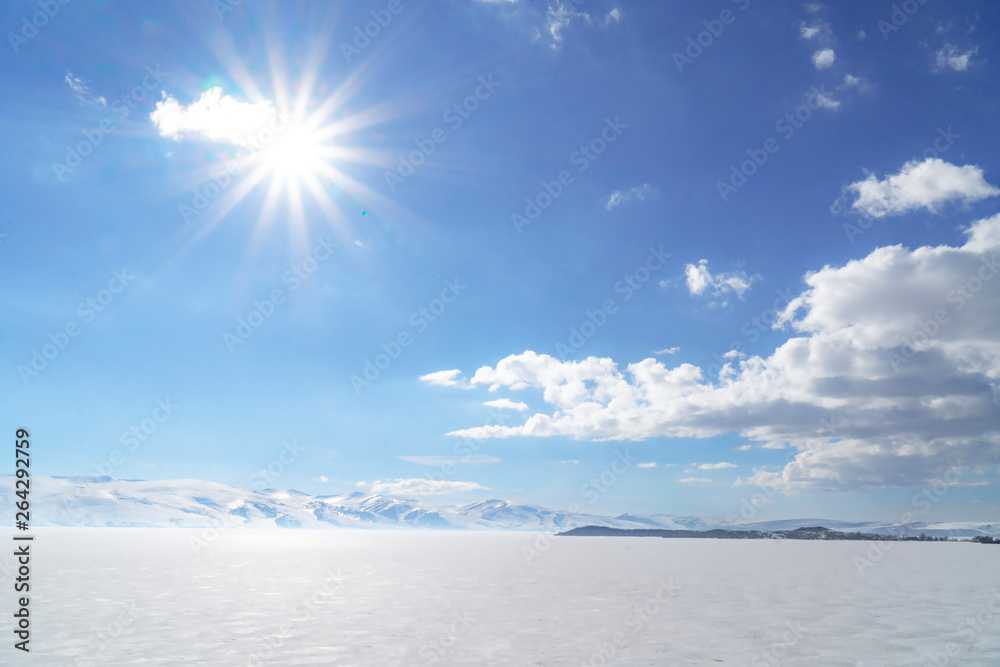 Obraz premium frozen lake with surrounding snow covered rocky mountains 