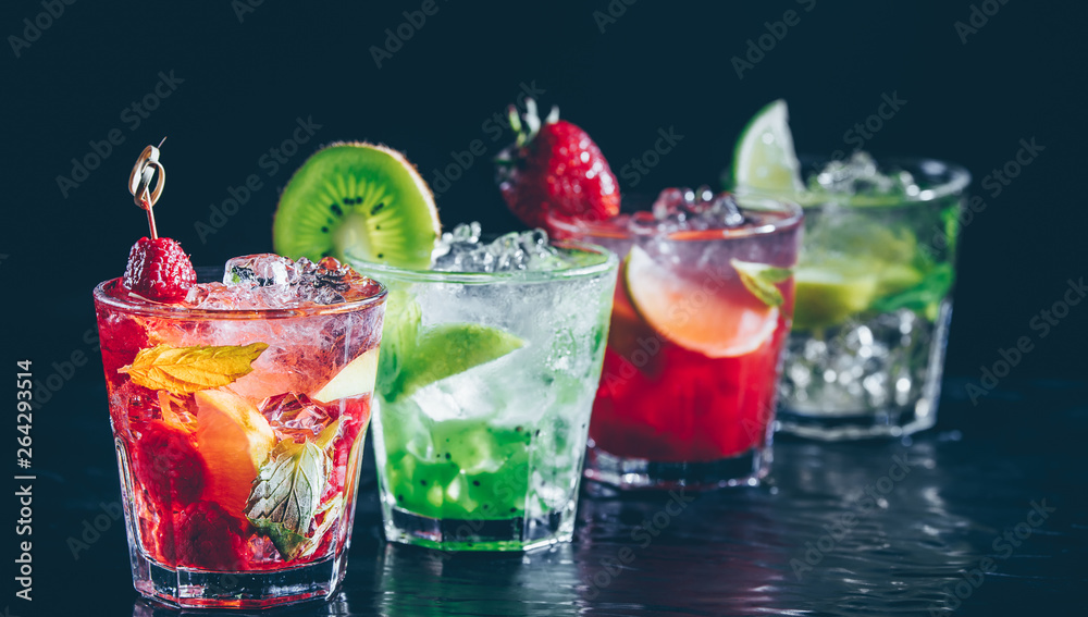 Four colorful tasty alcoholic cocktails in a row at the bar stand. Luxury vacation concept. Place for text. Banner wide screen format Four colorful tasty alcoholic cocktails in a row at the bar stand. Luxury vacation concept. Place for text. Banner wide screen format