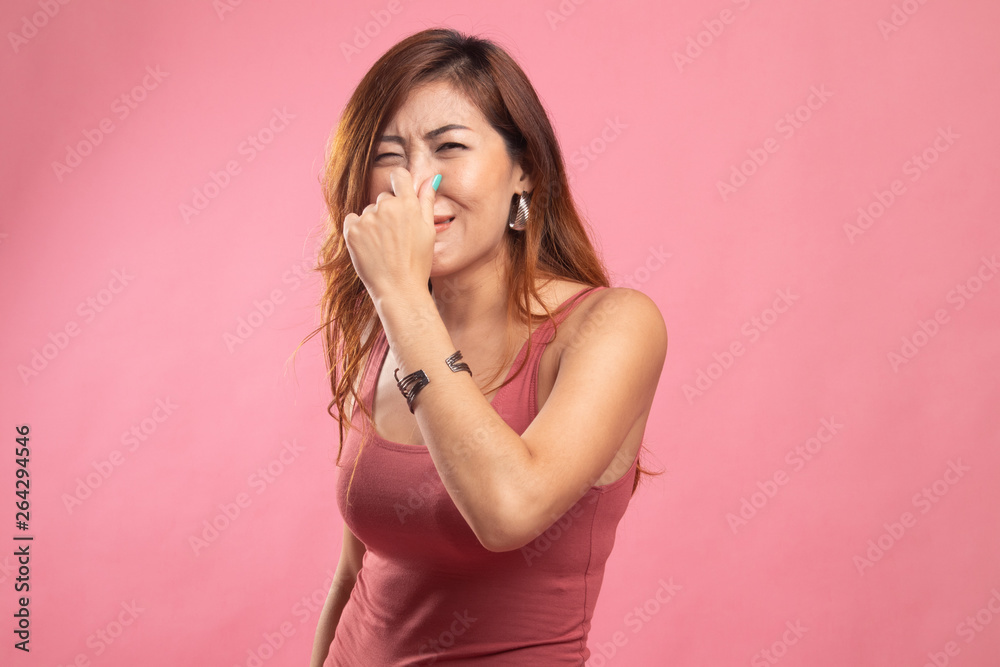 Young Asian woman  holding her nose because of a bad smell. - obrazy, fototapety, plakaty 
