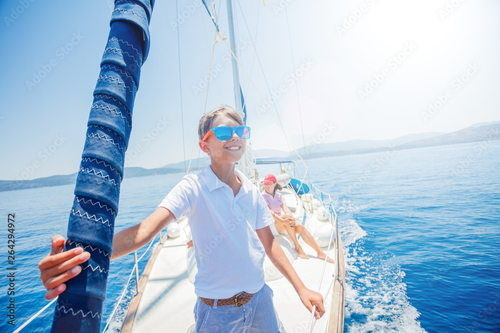 Little boy with his mother having fun on board of yacht on summer ...