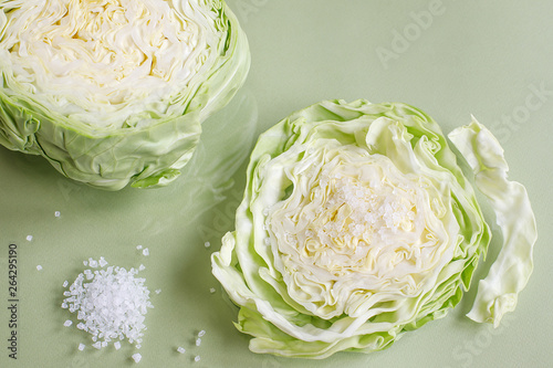 white cabbage slice and coarse sea salt on light green background photo