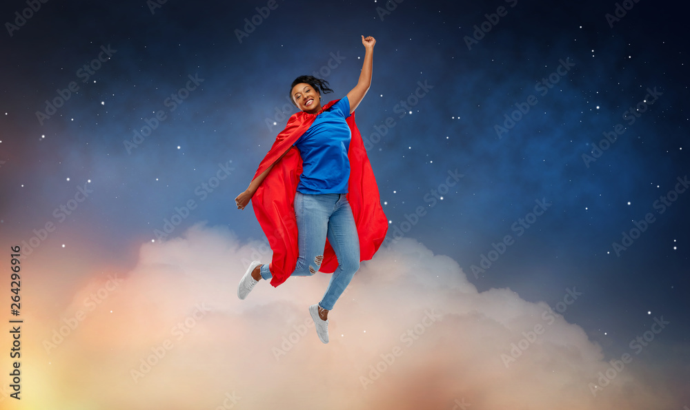 super power and people concept - happy african american young woman in superhero red cape flying over starry night sky and clouds background super power and people concept - happy african american young woman in superhero red cape flying over starry night sky and clouds background