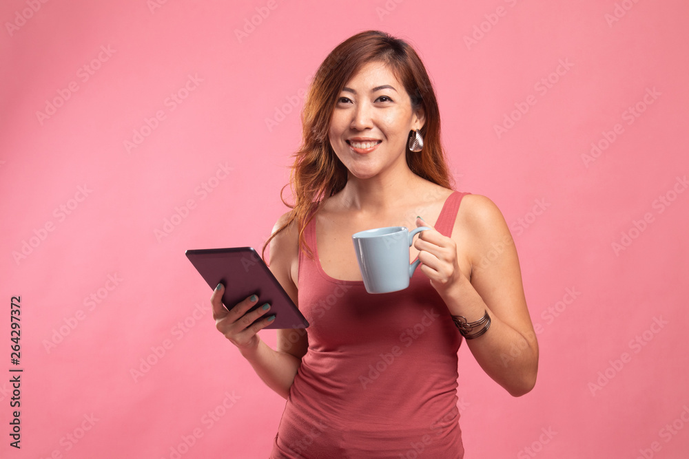 Young Asian woman with a computer tablet and coffee. Young Asian woman with a computer tablet and coffee.