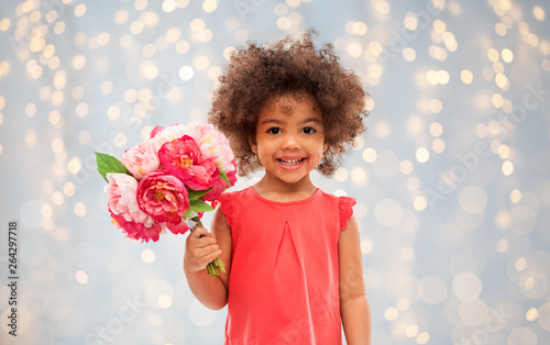 childhood and people concept - happy little african american girl with flowers over festive lights background