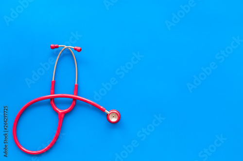 diagnostic and cure of cardiac disease with stethoscope on blue background top view mock-up