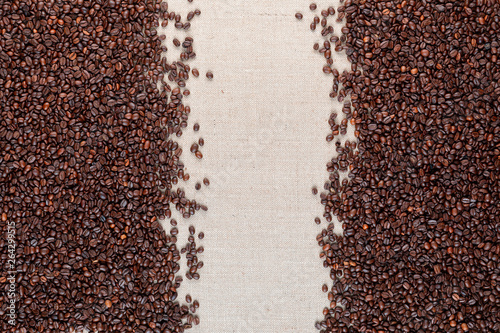 Roasted coffee beans on linea canvas with space in the middle.