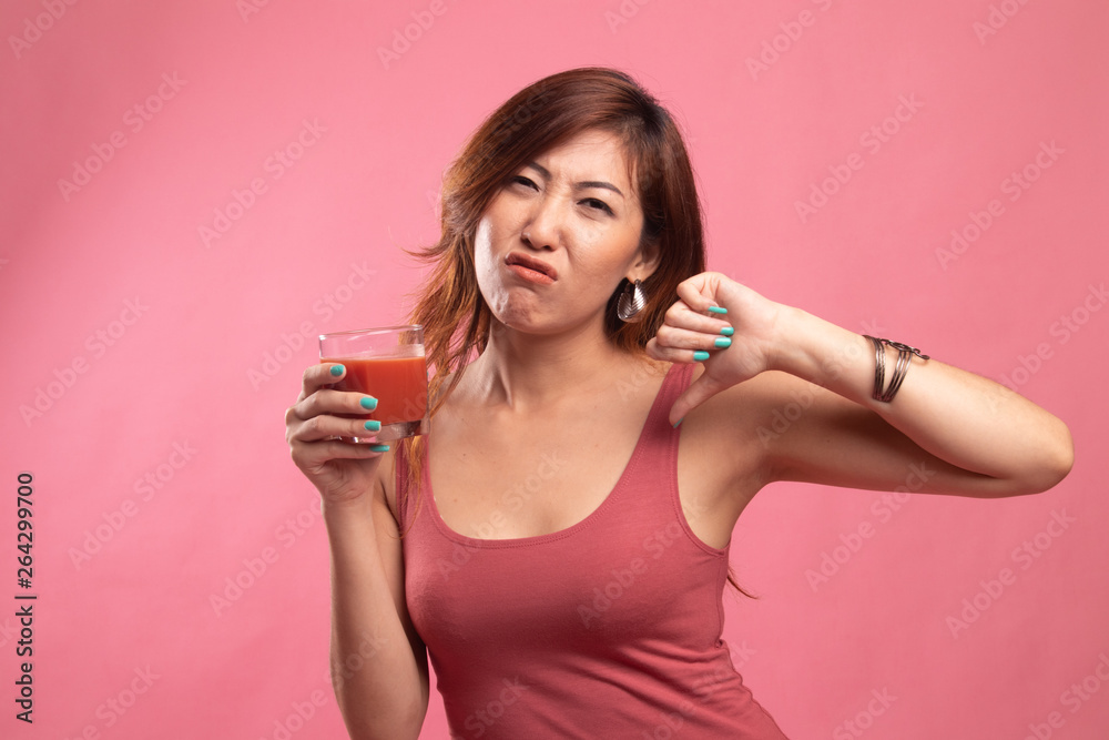 Asian woman thumbs down hate tomato juice. Asian woman thumbs down hate tomato juice.