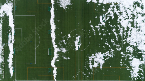 Football field in snow in the winter. A white marking on a green field.