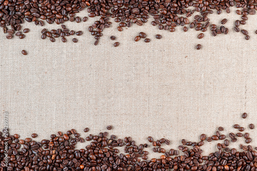 Roasted coffee beans on linea canvas with space in the middle.