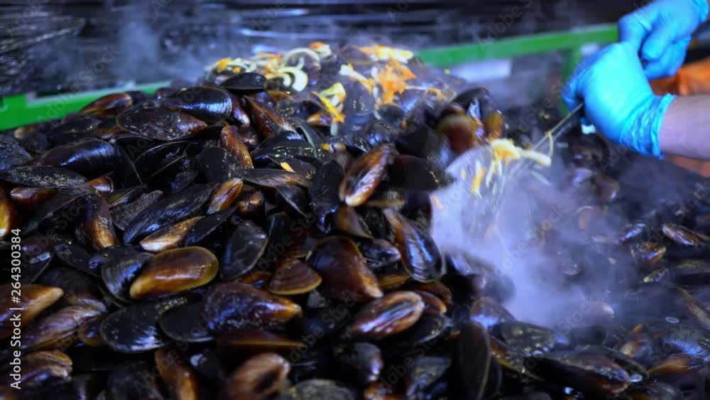 Mussels in the shell. Cook fries mussels in a large frying pan. Seafood