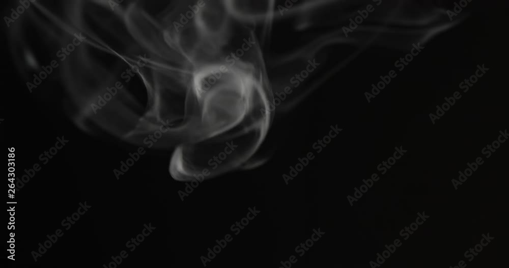 White smoke floating through space against black background White smoke floating through space against black background