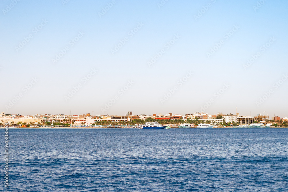 Hurghada coastline with hotel and resort buildings. View on seascape from boat. Red sea, Egypt.