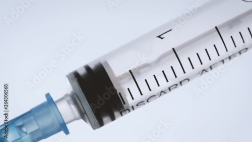 Closeup of a syringe injecting a vaccine into a patient. Macro shot of a plunger administering drugs. Anti-vaxxers refusing to vaccinate children causes outbreaks of preventable diseases like measles.