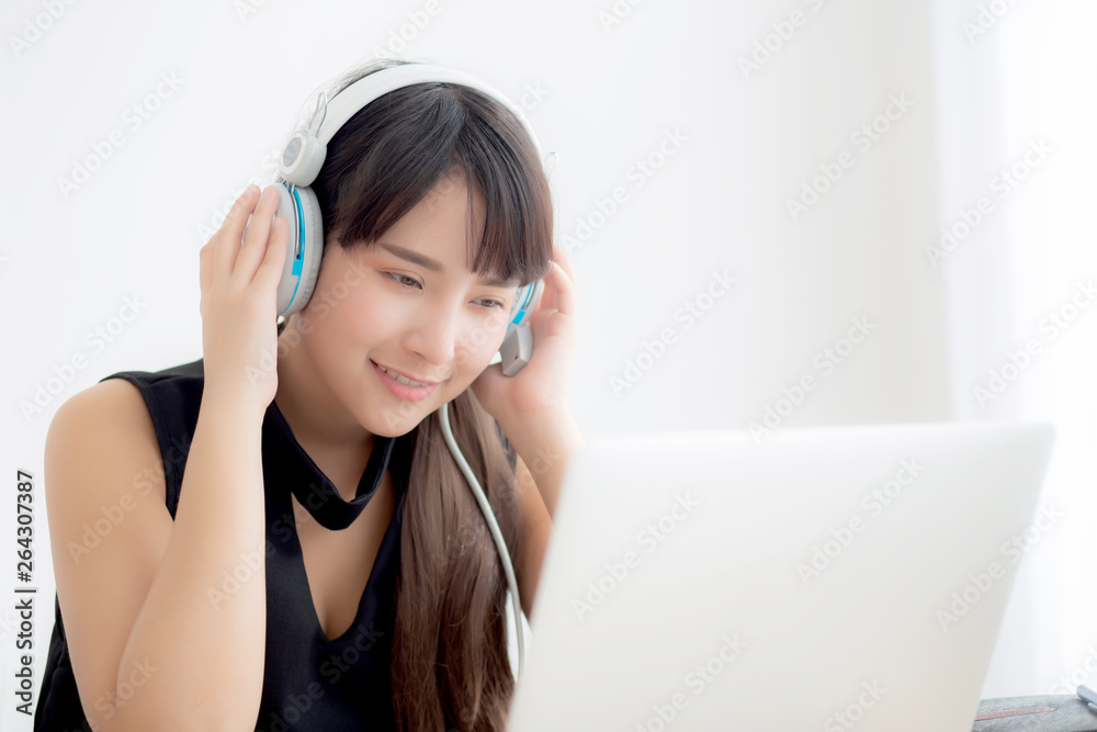 Beautiful young asian woman wear headphone smiling say hello using chat video call on laptop computer, girl relax enjoy listening music online, education learning, communication and lifestyle concept. Beautiful young asian woman wear headphone smiling say hello using chat video call on laptop computer, girl relax enjoy listening music online, education learning, communication and lifestyle concept.